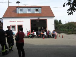Die Besucher des Feuerlöscheraktionstages sitzen vor dem Feuerwehrhaus in Rieblingen.