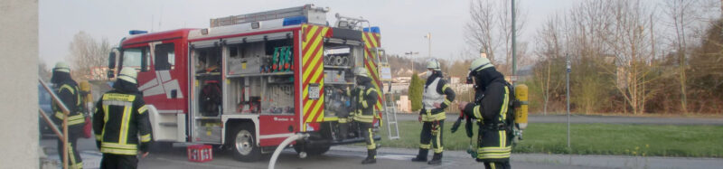 MLF mit Feuerwehrleuten vor dem alten Bezirkslagerhausgebäude in Gottmannshofen. Atemschutzübung.